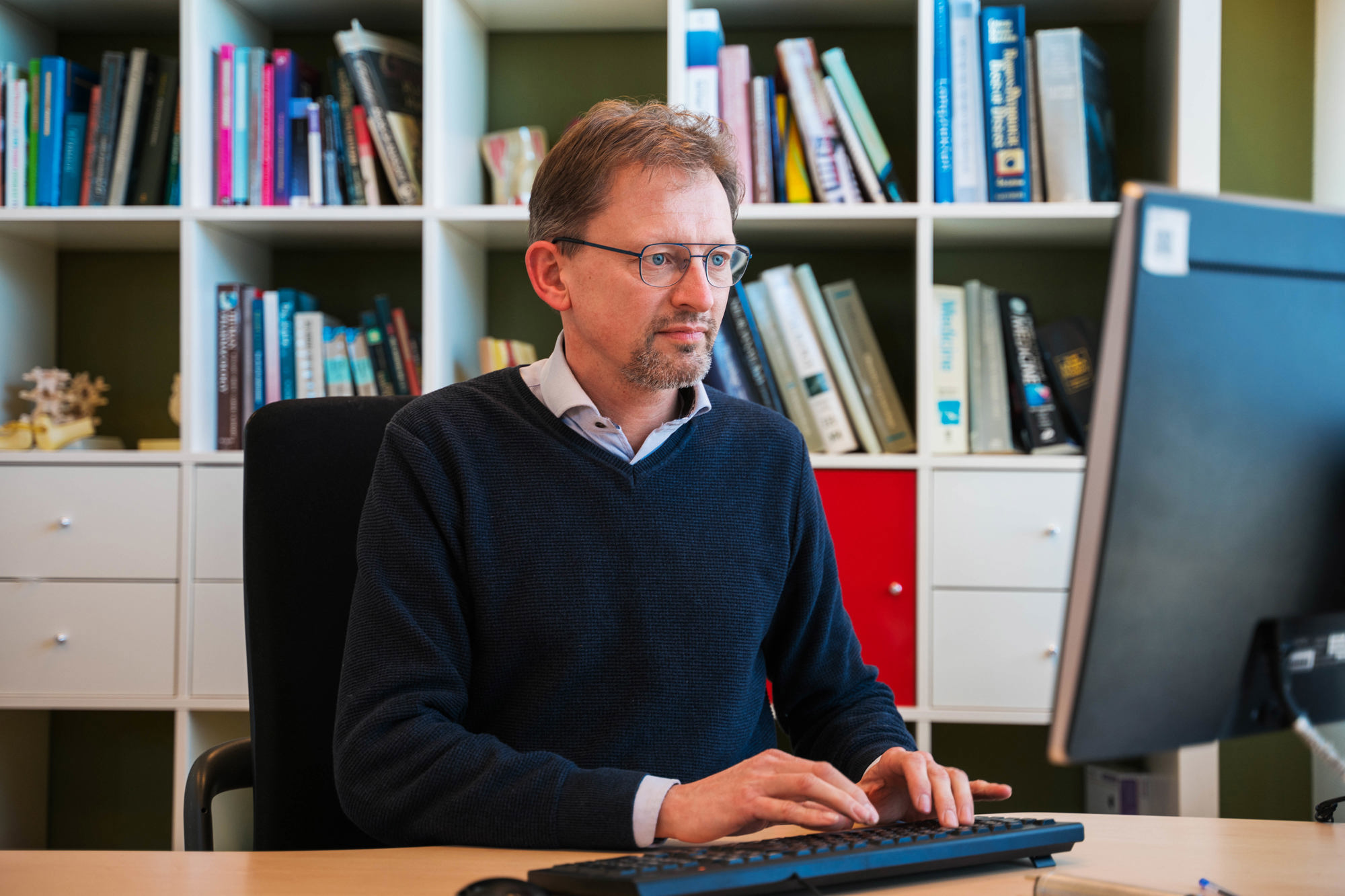 portret hans ramaker achter computerscherm